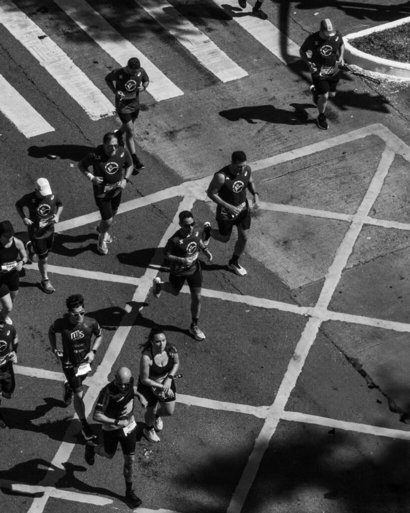 Black and white aerial shot of runners in a Sao Paulo marathon on city streets.